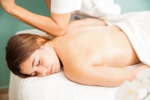 une cliente reçoit un massage sportif avec les coudes du masseur